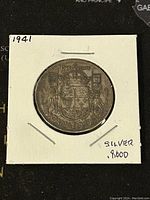 Reverse of the 1941 Canadian 50 cents silver coin displaying Canadian coat of arms, denomination and date.