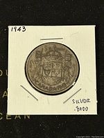 Reverse side of the 1943 Canadian 50 cent silver coin showing the coat of arms and inscriptions.