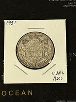 Reverse side of the 1951 Canadian 50 cents silver coin showing the Canadian coat of arms.