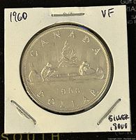 Obverse side of the 1960 Canadian silver 1 dollar coin showing the canoe design and inscriptions.