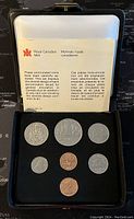 Photo of 7 uncirculated Canadian coins in black Royal Canadian Mint display case with an informational leaflet