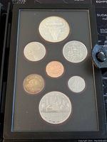 Overview of seven coins in black display case including the silver double dollar, other denominations with 50% silver content.