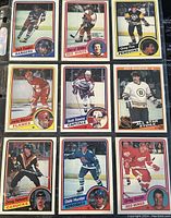 Nine NHL hockey trading cards from 1984-85 O-Pee-Chee series laid out in a 3x3 grid showing front sides with players and teams.