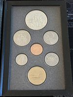 Front view of Canadian 1990 proof coin set showing seven coins including a large double dollar coin, various smaller silver coins, and a copper penny in foam casing.