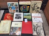 Top down photo of ten boxed art books showing covers with various art portraits, classical drawings, and painting instructional titles