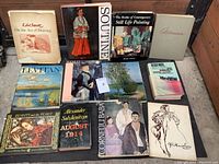 Image showing 12 art books arranged closely together, titles and cover art visible