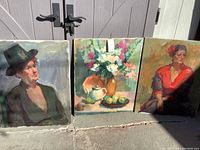 Three paintings side by side, including two portraits and one still life, all painted on canvas with visible brushstrokes.