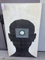 Full view of the large framed painting showing a black silhouette with a central circular painting of clouds inside the head area on a white background.