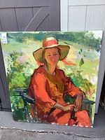 Full view of the colorful painting showing the seated woman in a red dress and large hat, outdoors with green and blue background.