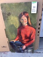 Framed oil painting on board showing seated woman in red sweater against green background. Shows overall view with wear to edges.