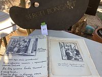 Page of open sketchbook with loose sketch, handwritten notes in Russian, and page from a sketchbook.