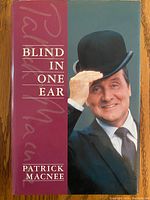Front cover of the book 'Blind in One Ear' by Patrick Macnee, showing the title and a photo of Patrick Macnee tipping his hat.