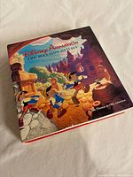 Front and top angle view of the large hardcover Disney Animation book with colorful illustrated cover showing Pinocchio and other characters.