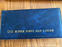 Blue folder for storing first day covers with gold text 'SUPER FIRST DAY COVER'