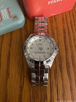 Photo of the Fossil stainless steel wristwatch with white dial showing 20 years Springbank logo and date window.