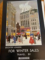 Colorful vintage-style poster showing Oxford Circus winter sales scene with London Underground signage and a large cherub figure.