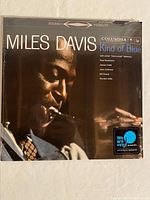 Front view of the sealed Miles Davis 'Kind of Blue' vinyl album cover with photo of Miles Davis playing trumpet, Columbia records logo and 'We are vinyl' sticker.