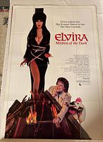 Full view of original movie poster featuring Elvira and other characters, with title and credits on white background.