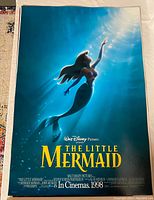 Original 1998 The Little Mermaid movie poster side featuring Ariel reaching toward light underwater in blue tones.