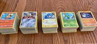 Five stacks of Pokémon cards arranged upright showing various character cards on top including Growlithe, Absol, Totodile, Maractus, Marill.