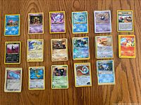 17 Pokémon cards spread in rows on wooden surface
