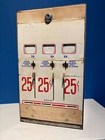 Front view showing three 25 cent slots with coin instructions and stamp receiving slots at bottom