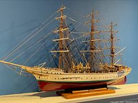 Full left side profile of the model ship showing hull paint and rigging