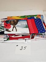 Stack of folded Christmas-themed fabric panels with visible reindeer print and red holiday scarf.