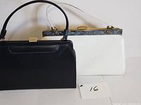 Two vintage handbags side by side, black handbag in front, white handbag behind with marble-like clasp and frame.