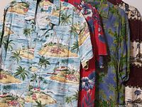 Front view of all four Hawaiian shirts on hangers, showing assorted tropical patterns and colors