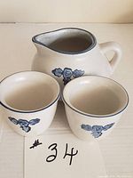 Full view of gravy boat/creamer and two custard cups showing overall appearance and floral design.