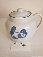 Front view of cream-colored stoneware bean pot decorated with blue floral Yorktowne pattern and handle