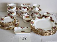 All 36 pieces arranged including stacked cups, saucers, plates, sugar bowl and small dish