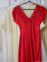 Red nightgown displayed with lace neckline and flutter sleeves in front of lighter colored clothing