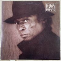 Front cover of Miles Davis Decoy vinyl record album showing a portrait of Miles Davis wearing a hat.