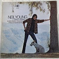 Front cover of the vinyl LP album 'Everybody Knows This Is Nowhere' by Neil Young with Crazy Horse showing the artist and a dog beside a tree.