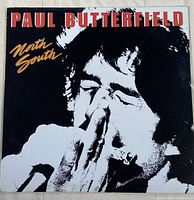 Front cover of the vinyl record album 'North South' by Paul Butterfield. Image shows a high-contrast black and white photo of Butterfield playing harmonica, with the title and artist in red and yellow text.