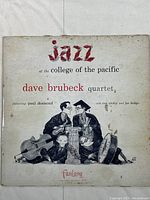 Front cover of the vinyl record jacket showing artwork and title: Jazz at the College of the Pacific by Dave Brubeck Quartet featuring Paul Desmond, Ron Crotty, Joe Dodge. Cover shows wear and staining.