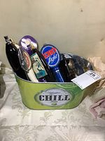 View of the metal Miller Chill Lime beer bucket with six different beer tap handles inside, showing various colors and logos.