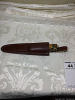 Closed leather sheath containing the cutter inside.