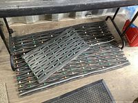 Pair of rubber entrance mats placed on wooden floor beneath a bench, large mat dimensions approximately 42x24 inches and smaller mat approximately 24x13 inches.