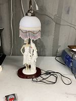 Full front view of lamp on surface showing overall height, design and condition