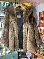 Full view of the Ashley Furs fur coat showing natural brown fur and black lining, hanging from a hanger.