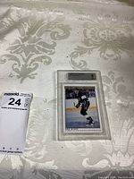 Front view of Rob Blake hockey card graded 9 by Beckett in plastic case on patterned white surface