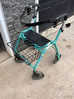 Angled side view of the light blue collapsible mobility cart showing the seat, hand brakes, and front basket.