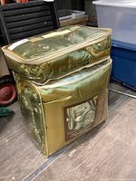 Two images of the bedding set in original fabric storage bag, showing its size and condition. Bag is gold and clear plastic with zipper, zipper broken.