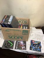 Photo showing the box full of PlayStation 2 games and loose discs including a Lego PS3 disc