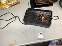 Front angle showing the Regency D810 scanner with visible numeric keypad, volume and squelch knobs, antenna, and LED indicators.