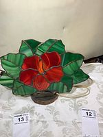 Front view of vintage stained glass lamp panel showing floral design with red petals and green leaves on a white background.