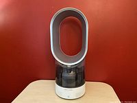 Front view of assembled humidifier on tabletop against red backdrop